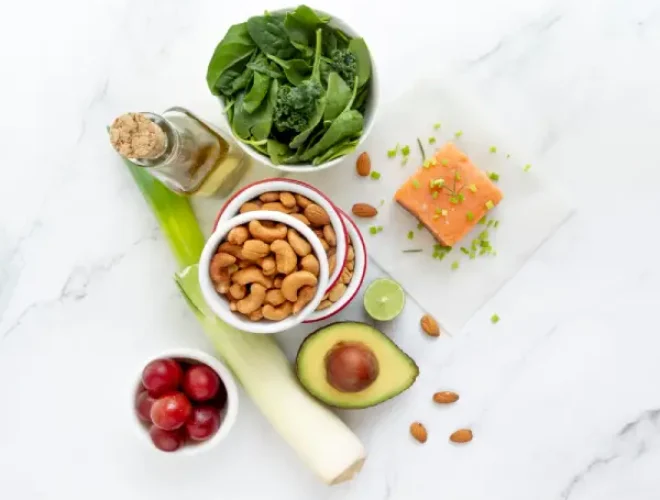 Alimentos que ayudan a reducir la ansiedad: salmón, espinacas, aguacate, frutos secos y verduras frescas.