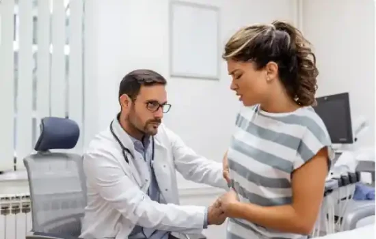 Profesional sanitario examinando a una paciente durante una revisi&oacute;n relacionada con insuficiencia renal