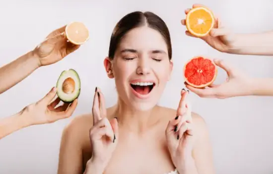 Dieta Perricone: mujer rodeada de aguacate y cítricos, alimentos ricos en antioxidantes y grasas saludables para cuidar la piel