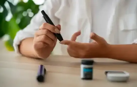 Persona administrándose insulina con pluma en el abdomen para controlar la glucosa en sangre