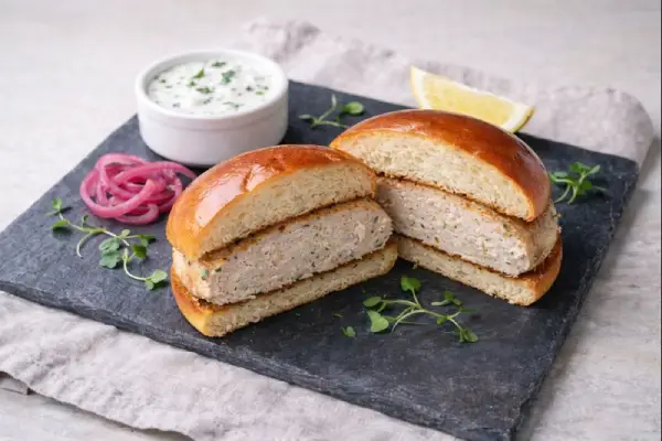 Hamburguesas de pollo caseras doradas a la plancha con ajo, perejil y comino, servidas en plato con guarnici&oacute;n ligera.