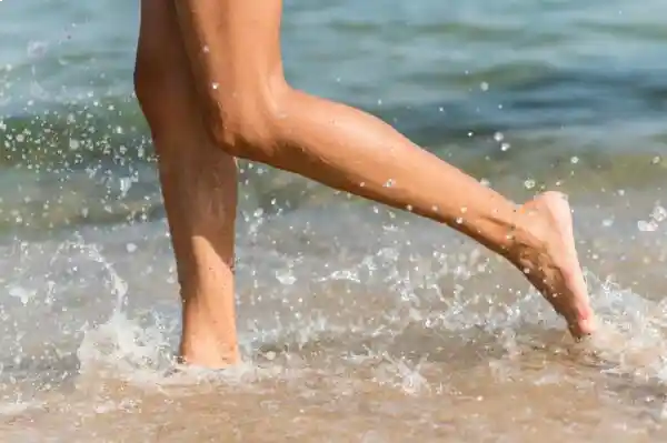 Más resistencia, menos impacto: caminar en el agua cambia el juego. Persona caminando en agua a media pantorrilla en la orilla del mar para hidrocaminata para adelgazar en primavera