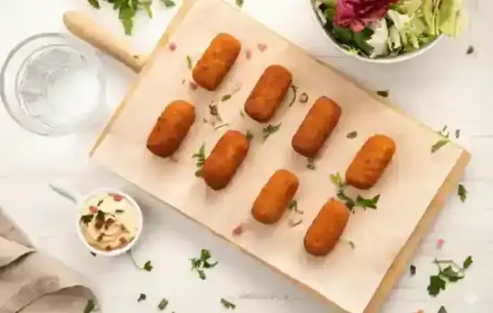 Tuppers con comida de aprovechamiento etiquetados y restos de verduras listos para hacer caldo en una cocina
