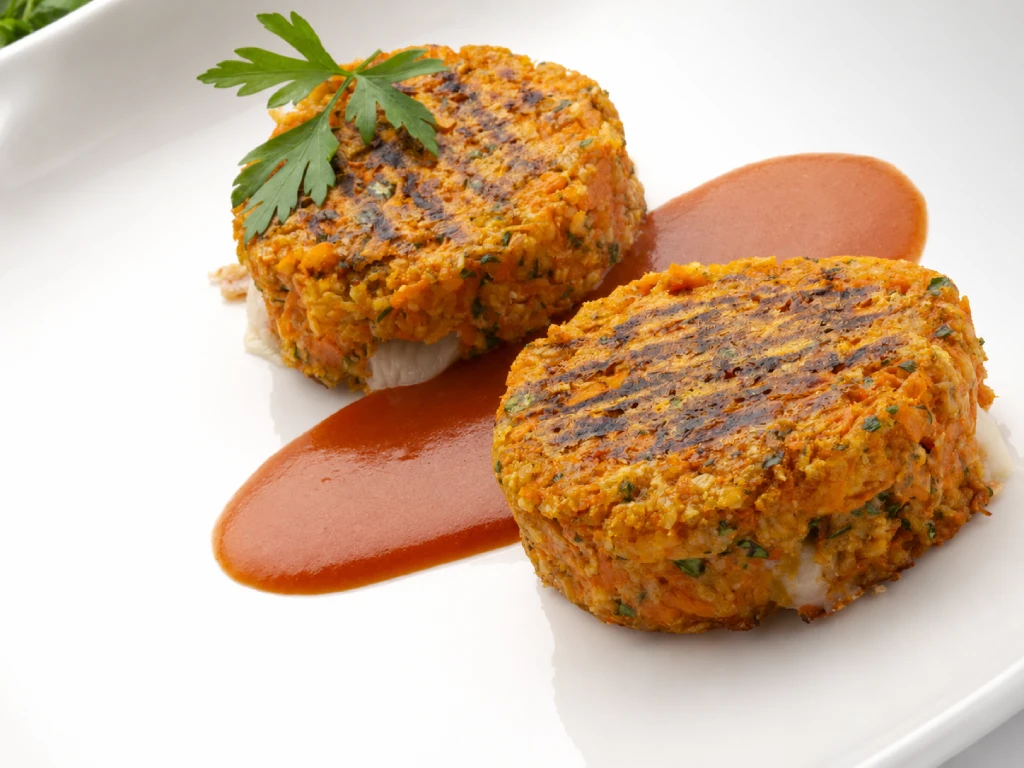 Hamburguesas de calabaza con ternera, jugosas y doradas, servidas en plato blanco con fondo neutro