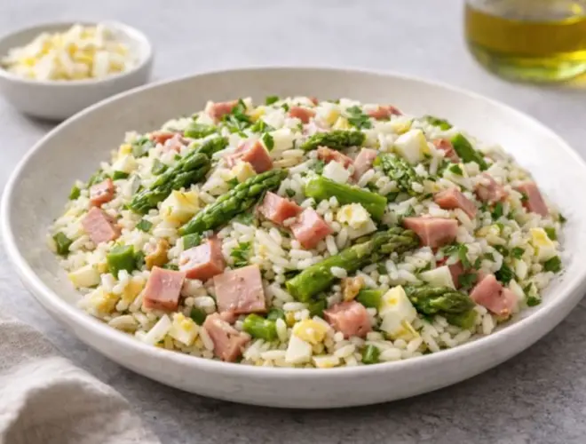 Arroz con jam&oacute;n y esp&aacute;rragos servido en plato cer&aacute;mico neutro, con esp&aacute;rragos verdes y huevo cocido, luz natural y acabado gourmet.