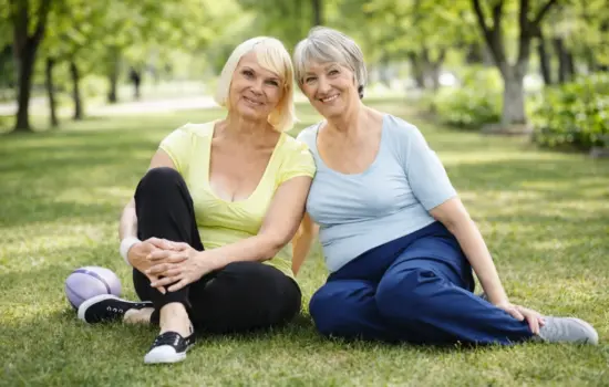 mujeres mayores sentadas en el parque cuidando su salud ósea y previniendo la osteoporosis