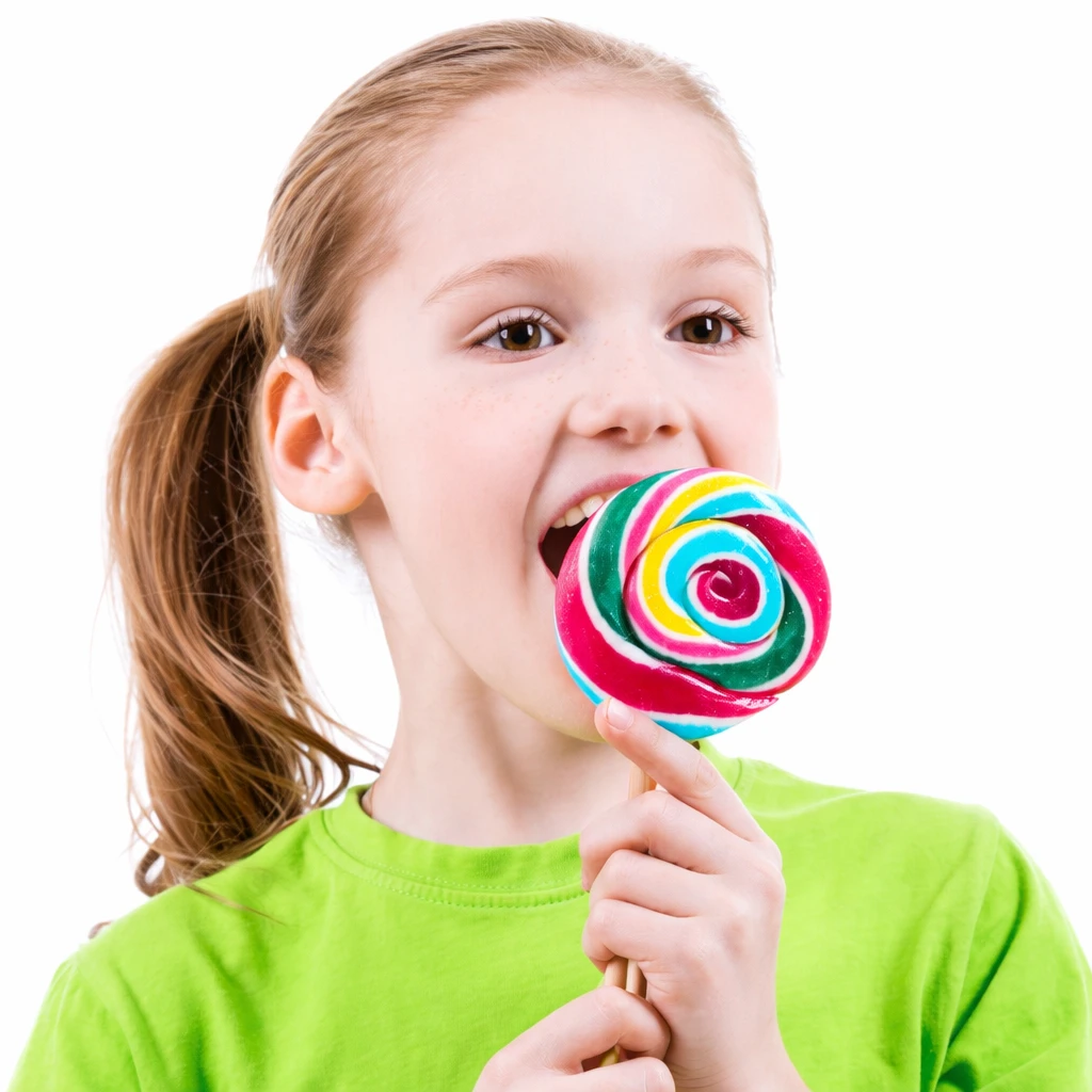 chucherias-y-calorias-como-afectan-a-la-alimentacion-infantil calorías de las golosinas en una niña comiendo piruleta de colores