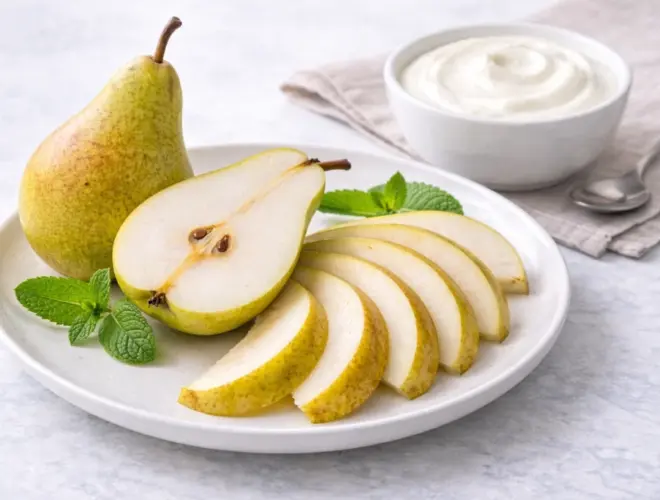 Dos piezas de fruta troceada de temporada servidas en bol con yogur desnatado 0% aparte, en una presentaci&oacute;n luminosa.