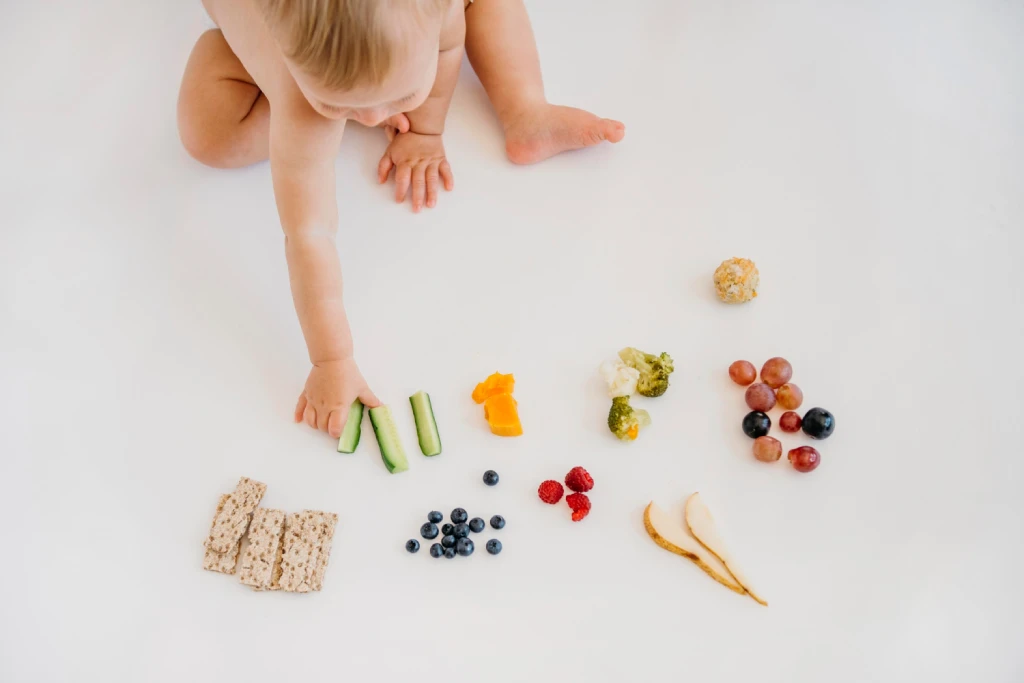 educar-en-nutricion-y-alimentacion-infantil-el-mejor-regalo-para-tus-hijos Bebé comiendo alimentos saludables como frutas, verduras y cereales en una alimentación infantil equilibrada