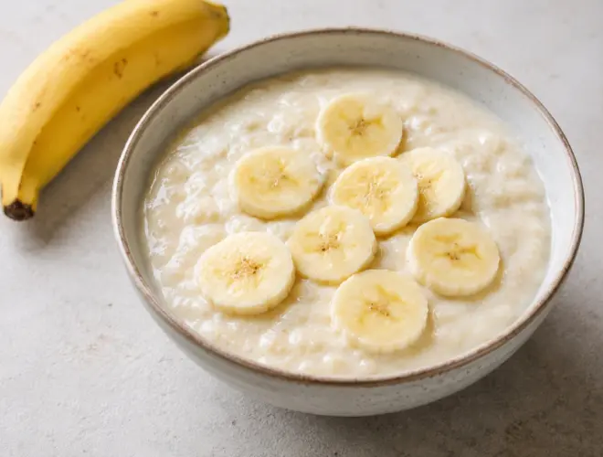 Crema de arroz con leche sin lactosa cremosa en cuenco de cer&aacute;mica, lista en 10 minutos y pensada para servir con pl&aacute;tano