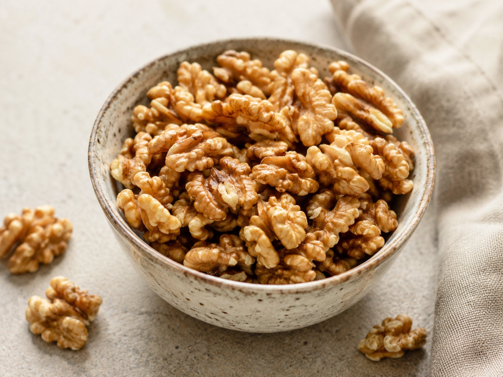 Raci&oacute;n de nueces peladas en un cuenco de cer&aacute;mica sobre fondo neutro, con luz natural y estilo gastron&oacute;mico saludable.